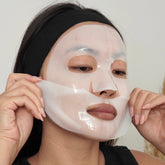 Person applying a face mask with a neutral background
